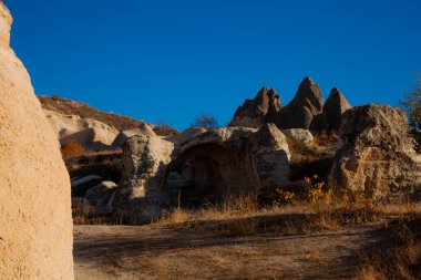Kapadokya 'daki volkanik oluşumlar açık mavi gökyüzüne karşı, Türkiye