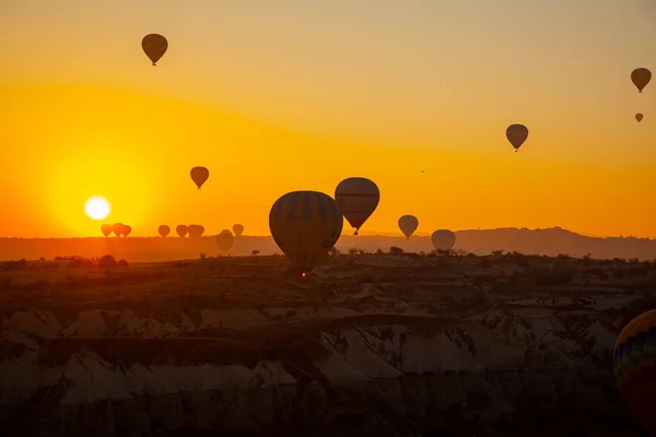 カッパドキア トルコ 2022年11月22日 黄色の空を背景に飛んでいるトルコの熱気球カッパドキアの日の出 — ストック写真