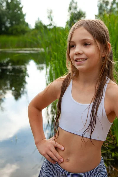 運動ティーンエイジャー少女は自然 夏の季節 曇った空の湖の近くを歩きます — ストック写真