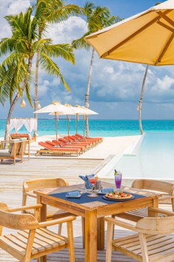 Kapalı masa yemekleri palmiye ağaçları, lüks otel havuz başında sonsuz havuz kokteylleri, açık hava restoranı plajı, okyanus ve gökyüzü, tropikal ada kafesi. Yaz tatili ya da tatil, aile seyahati