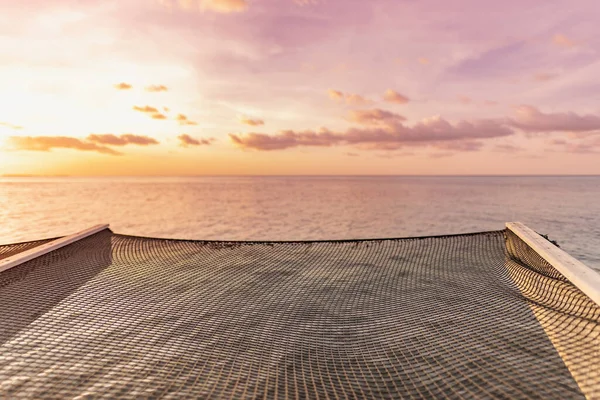 stock image Beautiful sunset tropical paradise sea beach. Tranquil summer vacation holiday landscape. Amazing sunset beach seaside with water hammock hanging on woods. Exotic nature view inspirational seascape