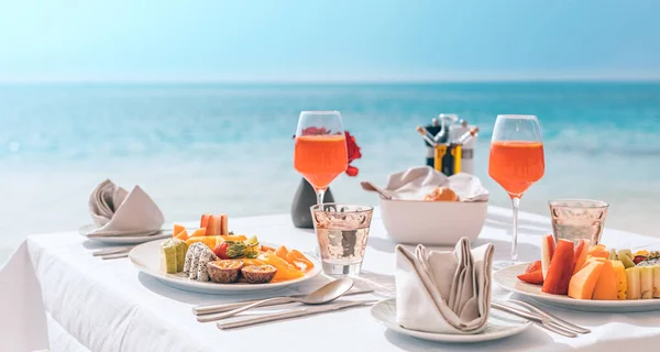 Luxury breakfast table with food for two with beautiful tropical sea view background. Morning couple time summer holiday and romantic vacation concept, luxury travel and lifestyle, destination dining