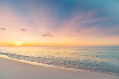 Sahilde. Güzel panoramik manzara, altın renkli günbatımı gökyüzü bulutları. Kumlu sahilde dalgaların hafifçe vurduğu sakin bir deniz. İnanılmaz gün doğumu manzarası, yaz doğası, huzurlu sahil.