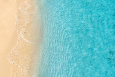 Sahildeki deniz dalgalarının göz kamaştırıcı manzarası. Sakin kristal berrak su. Çarpıcı yaz manzarası, güneşli tropikal ada kıyısı. 