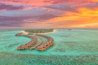 Maldivler adasında günbatımı mükemmel, lüks su villaları