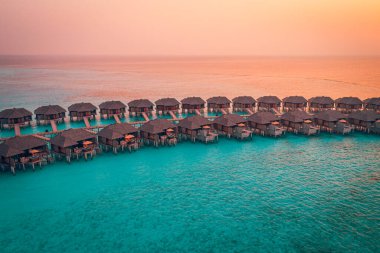Maldivler adasında günbatımı mükemmel, lüks su villaları