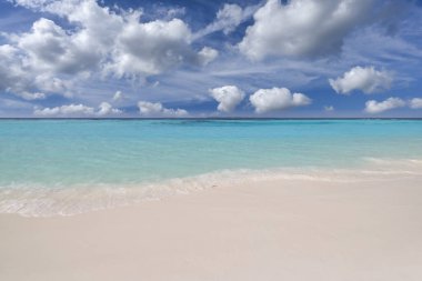 Yakın kumlu sahil, güneşli mavi deniz göğü. Panoramik plaj manzarası. Boş tropikal deniz kıyısı ve deniz manzaralı fotokopi alanı. Beyaz yumuşak kum dokusu, sakinlik, huzur veren güneş ışığı, yaz rüyası havası.