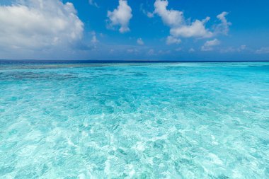 Yakın kumlu sahil, güneşli mavi deniz göğü. Panoramik plaj manzarası. Boş tropikal sahil ve deniz manzarası kopyalama alanı.