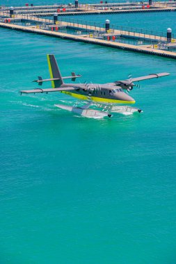 New floating dock at Male airport. Trans Maldivian Airways Twin Otter seaplanes. Exotic scene, seaplanes in calm ocean lagoon. Luxury travel clipart