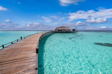 Turkuaz okyanus suyu ve bungalovlu ahşap köprü manzarası