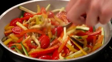 Şef baharatı karıştırarak ratatouille 'i bitirir.