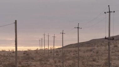 Çöldeki tahtadan elektrik direkleriyle ıssızlık.