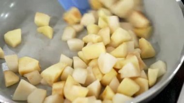 Pasta şefi pastaya reçel yapmak için elmaları tavada pişirir.
