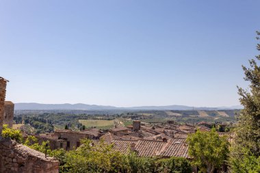 İtalya 'nın ortaçağ Toskana şehrinin eski çatıları, kiliseleri ve güzel Toskana vadisi manzarası..