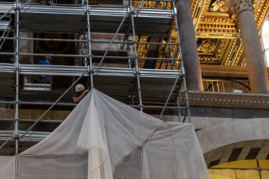 Siena, İtalya - 14 Temmuz 2024: Duomo di Siena 'da iç restorasyon çalışmaları (Santa Maria Assunta), perdeleri toplayan restoratör