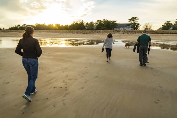 家人正在缅因州的日落海滩上散步 — 图库照片