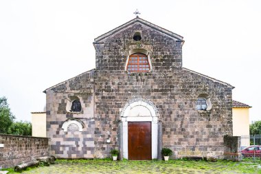 Caserta 'nın Calvi Risorta bölgesindeki yeşil tarlalarla çevrili eski ortaçağ Romanik Katedrali. İtalya