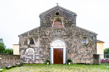 Caserta 'nın Calvi Risorta bölgesindeki yeşil tarlalarla çevrili eski ortaçağ Romanik Katedrali. İtalya