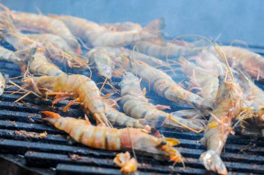 Arka planda ızgarada ızgara karides.