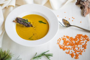 Arka plandaki tabakta et ve mercimek çorbası var.