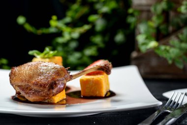 Beyaz tabakta ızgara ördek bacağı 