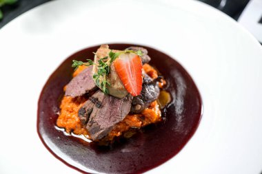 Sebzeli biftek ve arka planda çilek, yakın plan.