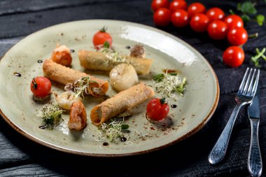 Siyah arkaplanda karides ve domatesli dolma börek..