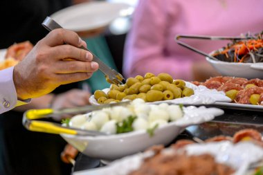 Restoranda açık büfenin yanındaki adam arka planda.