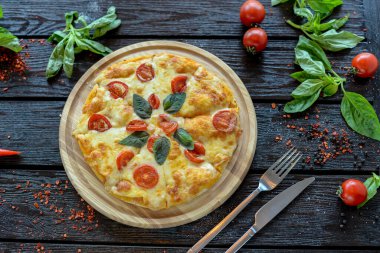 Peynirli pizza, domates ve fesleğen. İtalyan yemeği konsepti.