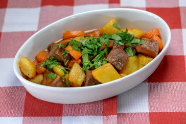 Arka planda sebzeli biftek yahnisi, yakın plan.