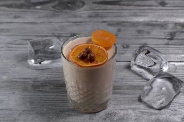 Arka planda buz ve portakallı bir bardak kokteyl, yakın çekim.