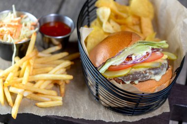 Patates kızartmalı burger, arka planda cips, yakın plan.