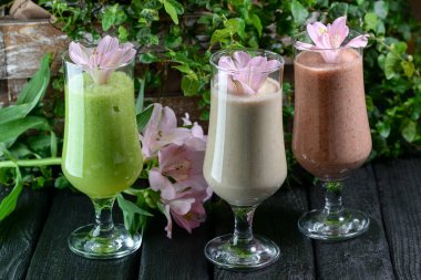 Masada taze çiçekler olan sağlıklı içecekler.