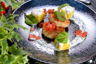 Kızarmış pirzola ve arka planda bitkiler.