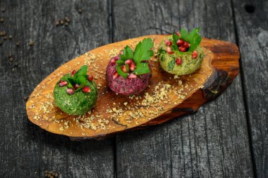 Masanın üzerinde top şeklinde Gürcü atıştırmalıkları ve nar tohumları var.