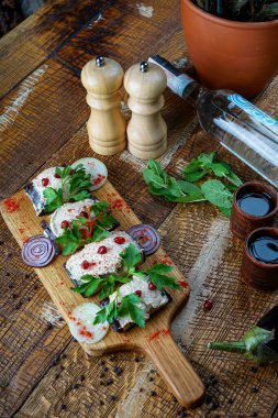 Gürcistan usulü patlıcan aperatifi. Masanın üzerine çaça ve bitki serpiştirilmiş nar tohumları serpiştirilmiş.