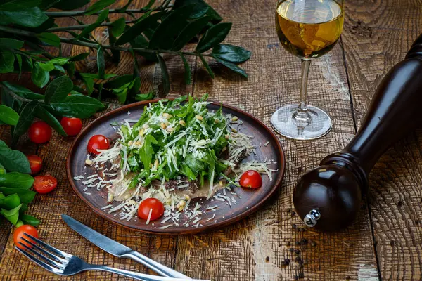 Bir tabakta roka, peynir ve nar tohumlu Gürcü salatası.