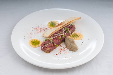 Bir tabak lezzetli etli tartar tostlu, yakından bak.