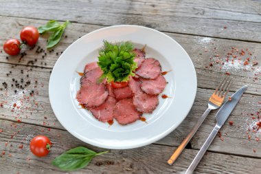 Ahşap masada baharatlı ve otlu çiğ et dilimleri. en üstteki görünüm