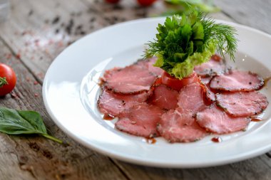 Ahşap masada baharatlı ve otlu çiğ et dilimleri. en üstteki görünüm
