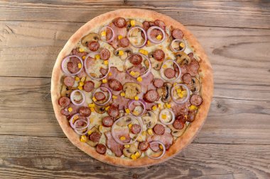 Etli, mantarlı, sosisli, mısırlı ve soğanlı acı biberli pizza