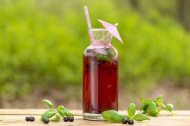 Arka planda taze ahududu ve yabanmersini kokteyli.