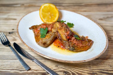 Soslu kızarmış balık, otlar ve limon.