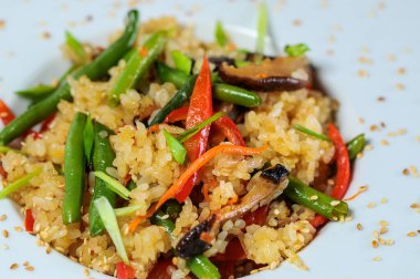 Bir tabak kızarmış pirinç, sebzeli, yeşil fasulye. 