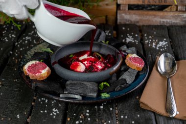 Ev yapımı kırmızı çorba, havyar ve yabani otlar.