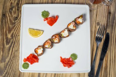  Japon mutfağı. Makki çatal ve bıçakla beyaz tabakta yuvarlanıyor.