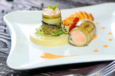 Kızarmış somon, salatalık, patates püresi, kruvasan ve çatal. 