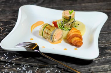 Kızarmış somon, salatalık, patates püresi ve kruvasan.