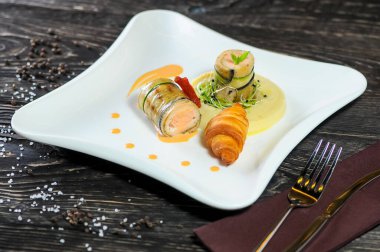 Lezzetli kızarmış somon, salatalık, patates püresi ve kruvasan.