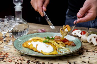 Kızarmış pastırmalı adam, patatesli mantar krep ve votka.